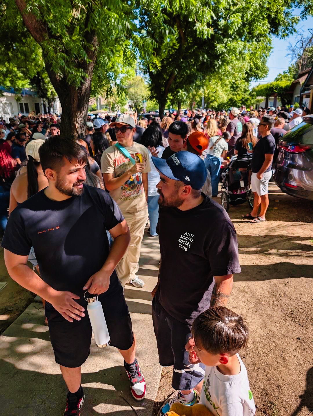 Juan connecting with community members at a packed park gathering